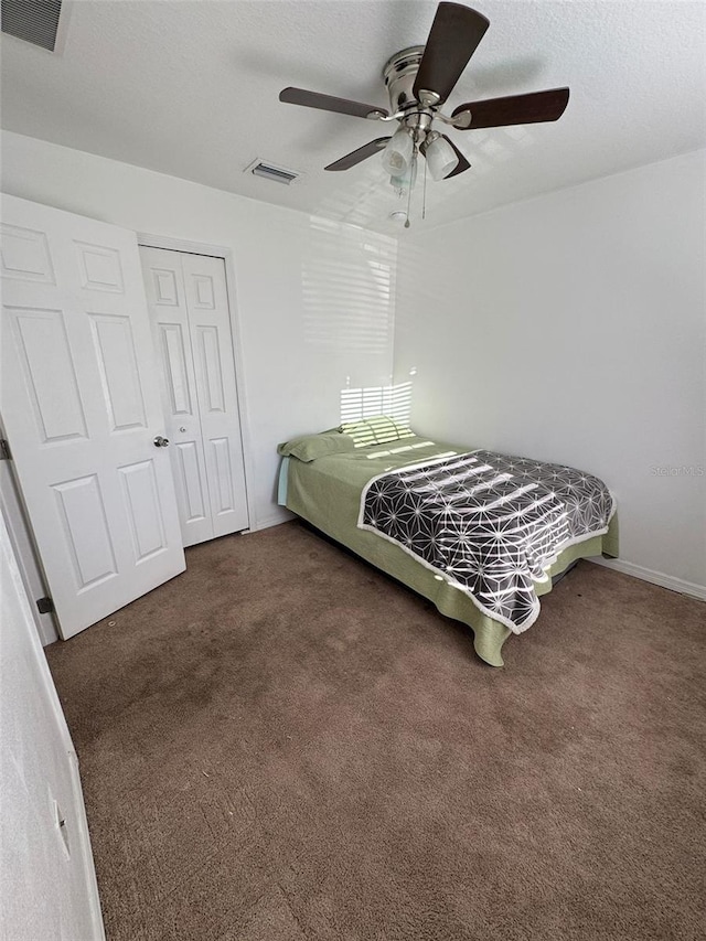 carpeted bedroom featuring a closet and ceiling fan