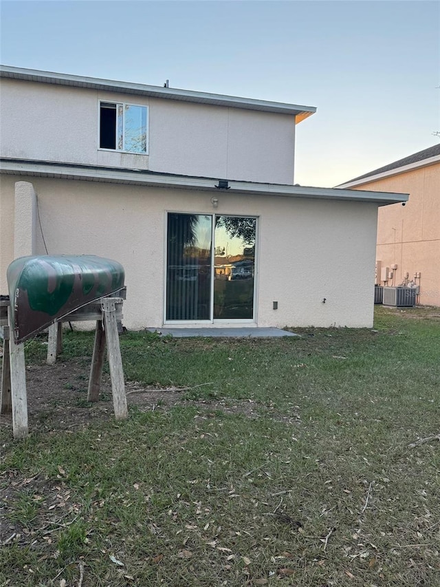 rear view of property with a yard and cooling unit