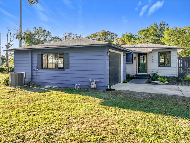 single story home featuring a garage, a front lawn, and central AC