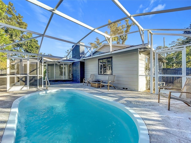 view of swimming pool featuring a lanai and a patio