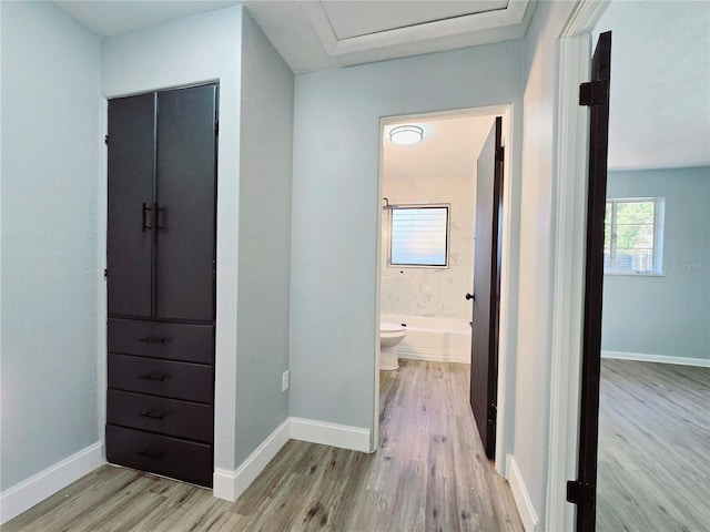 corridor with baseboards and wood finished floors