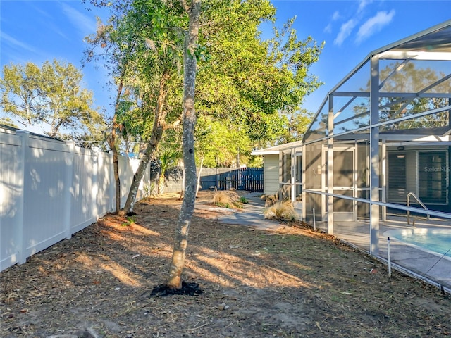 view of yard featuring a lanai, a fenced in pool, and a fenced backyard