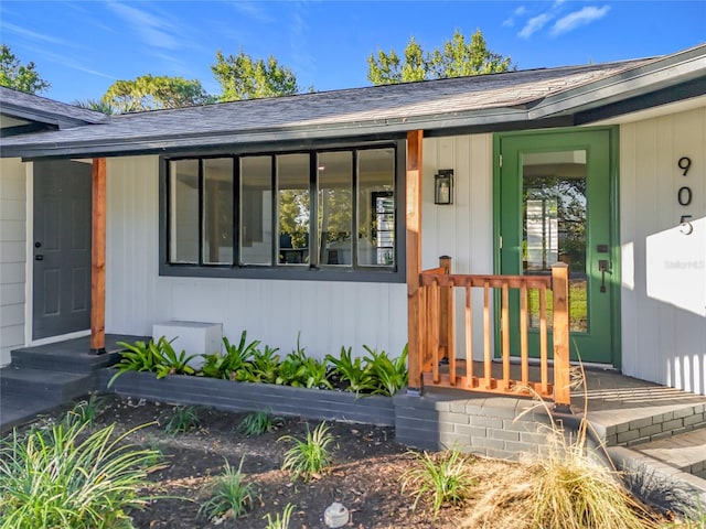 entrance to property featuring roof with shingles