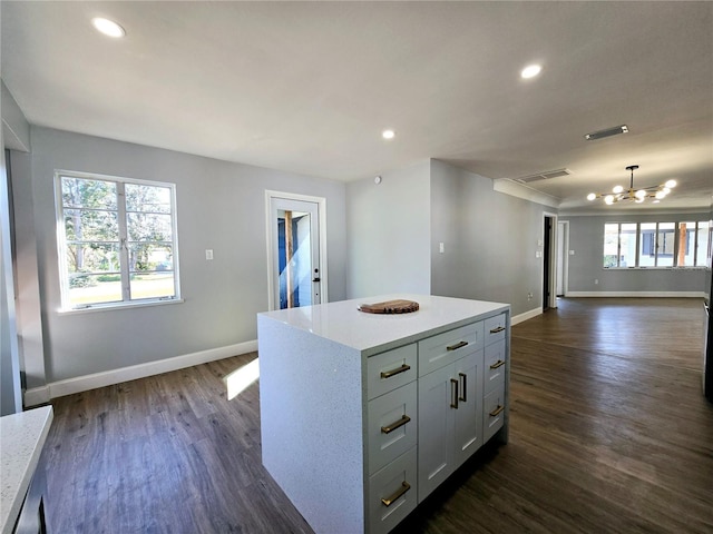 kitchen featuring a kitchen island, decorative light fixtures, white cabinetry, a chandelier, and dark hardwood / wood-style flooring