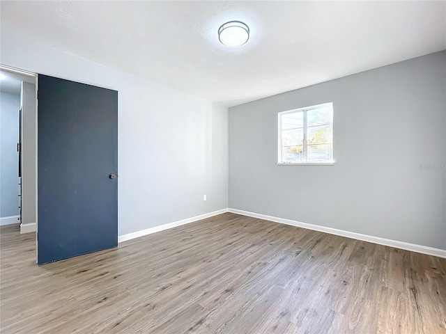 empty room featuring wood finished floors and baseboards