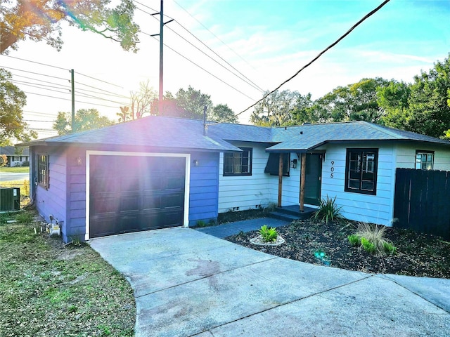 ranch-style house featuring a garage and central AC