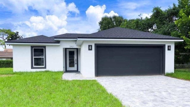 view of front of house featuring a garage and a front lawn