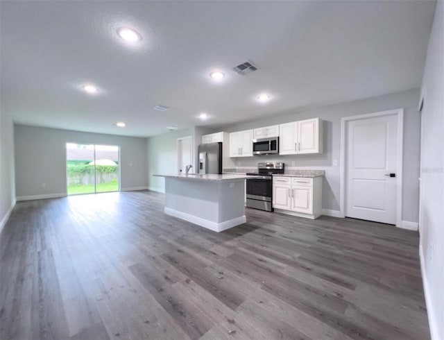 kitchen with white cabinets, a kitchen island, dark hardwood / wood-style flooring, and stainless steel appliances