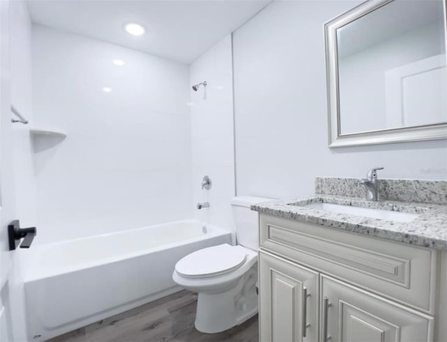 full bathroom featuring hardwood / wood-style floors, vanity, bathtub / shower combination, and toilet