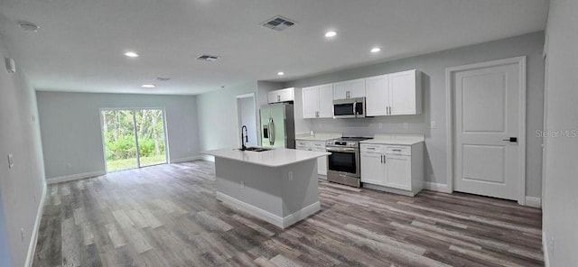 1030 Darlington Ct, Kissimmee, FL 34758 - kitchen with appliances with stainless steel finishes, wood finished floors, white cabinetry, and recessed lighting