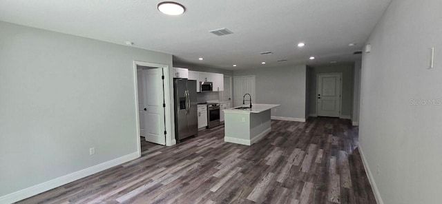 1030 Darlington Ct, Kissimmee, FL 34758 - kitchen featuring appliances with stainless steel finishes, white cabinetry, dark wood finished floors, a kitchen island with sink, and recessed lighting