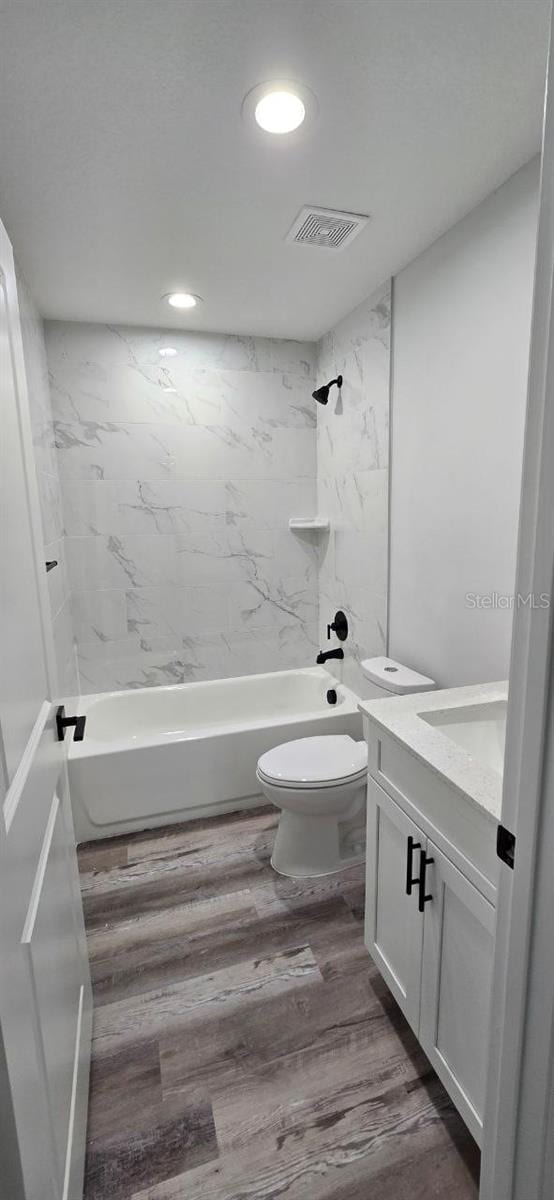 1030 Darlington Ct, Kissimmee, FL 34758 - bathroom with vanity, bathing tub / shower combination, wood finished floors, and recessed lighting