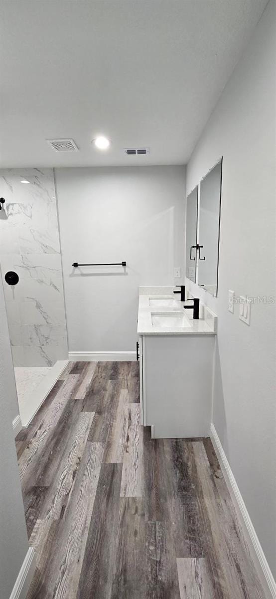 1030 Darlington Ct, Kissimmee, FL 34758 - full bathroom featuring vanity, a marble finish shower, wood finished floors, and recessed lighting