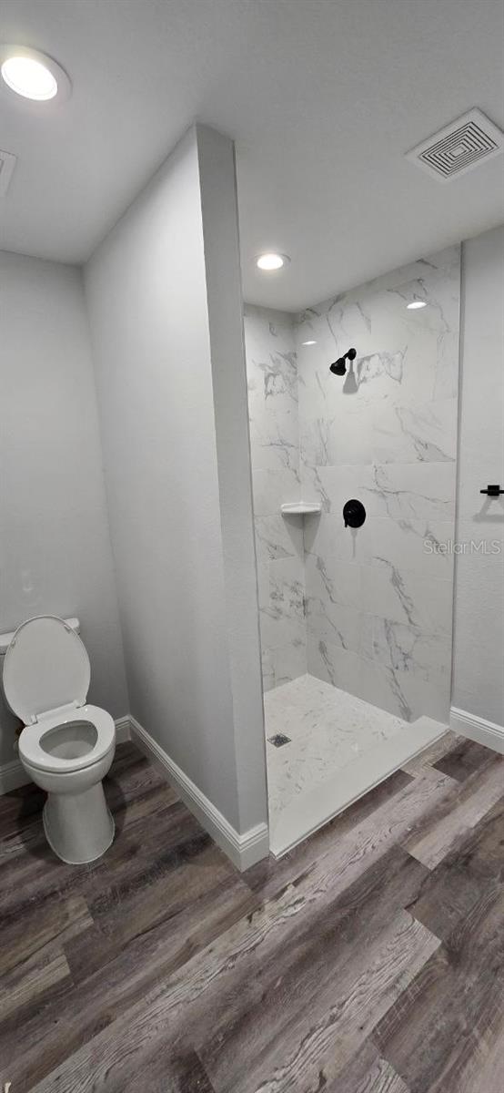 1030 Darlington Ct, Kissimmee, FL 34758 - full bath with a marble finish shower, wood finished floors, and recessed lighting