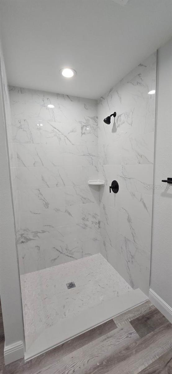 1030 Darlington Ct, Kissimmee, FL 34758 - full bathroom with a marble finish shower, recessed lighting, and wood finished floors