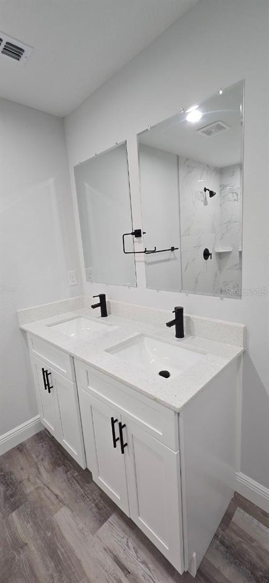 1030 Darlington Ct, Kissimmee, FL 34758 - full bath featuring double vanity, wood finished floors, and a marble finish shower