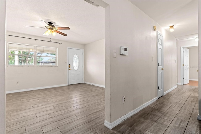 entrance foyer featuring a textured ceiling, light hardwood / wood-style floors, and ceiling fan