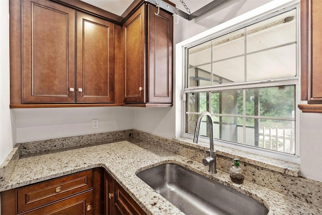 kitchen featuring light stone countertops and sink