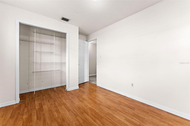 unfurnished bedroom with light hardwood / wood-style flooring and a textured ceiling