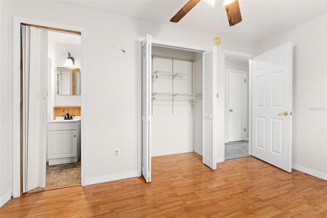 unfurnished bedroom with connected bathroom, ceiling fan, sink, light hardwood / wood-style floors, and a closet