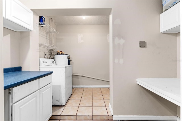 clothes washing area with cabinets, water heater, washer / clothes dryer, a textured ceiling, and light tile patterned floors