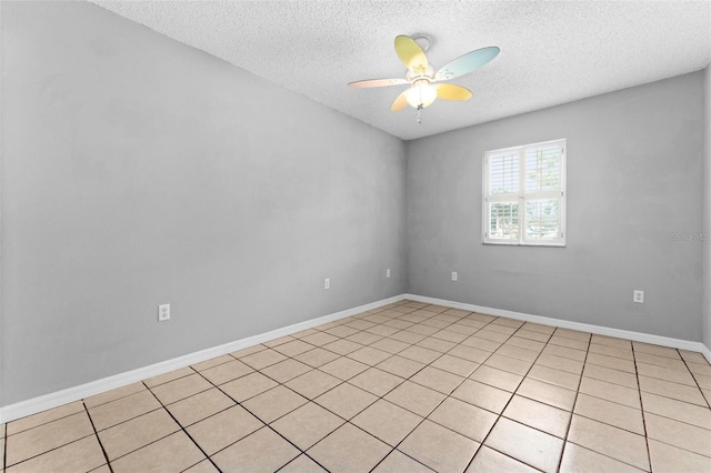 tiled empty room featuring ceiling fan and a textured ceiling