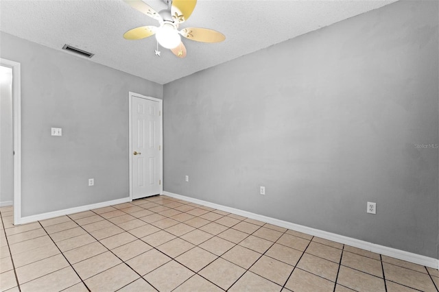 tiled spare room with ceiling fan and a textured ceiling