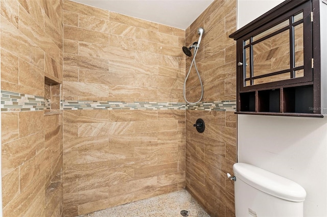 bathroom featuring tiled shower and toilet