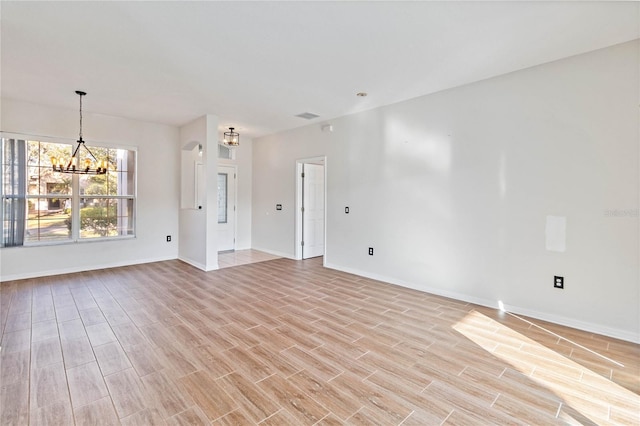 unfurnished living room with light hardwood / wood-style floors and a notable chandelier