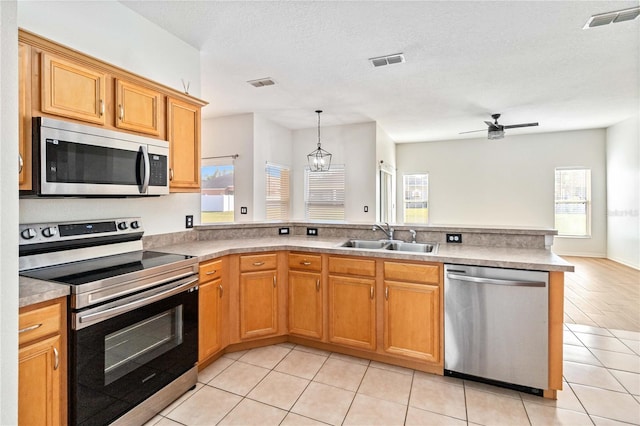 kitchen with light tile patterned floors, ceiling fan with notable chandelier, stainless steel appliances, and sink