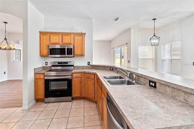 kitchen featuring pendant lighting, sink, light tile patterned floors, and stainless steel appliances