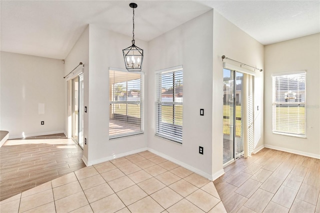 tiled foyer entrance with an inviting chandelier