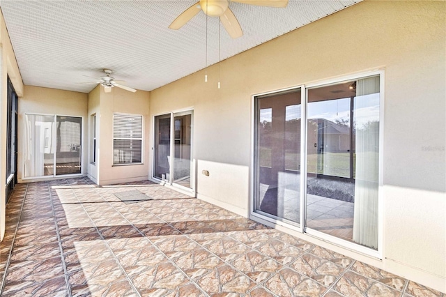 unfurnished sunroom with ceiling fan