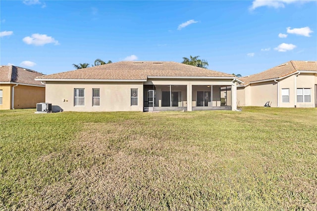 back of property featuring a yard, central air condition unit, and a sunroom