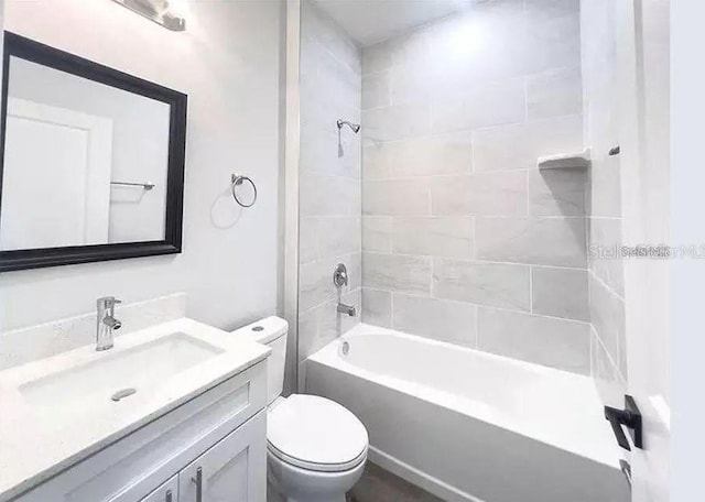 full bathroom with vanity, toilet, and tiled shower / bath