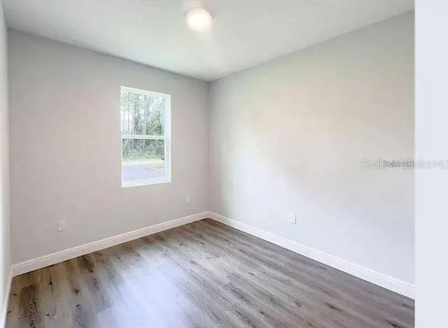 unfurnished room with hardwood / wood-style flooring