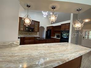 kitchen featuring pendant lighting, kitchen peninsula, hardwood / wood-style flooring, and a chandelier