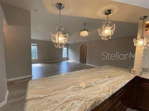 kitchen with hardwood / wood-style flooring, pendant lighting, and dark brown cabinetry