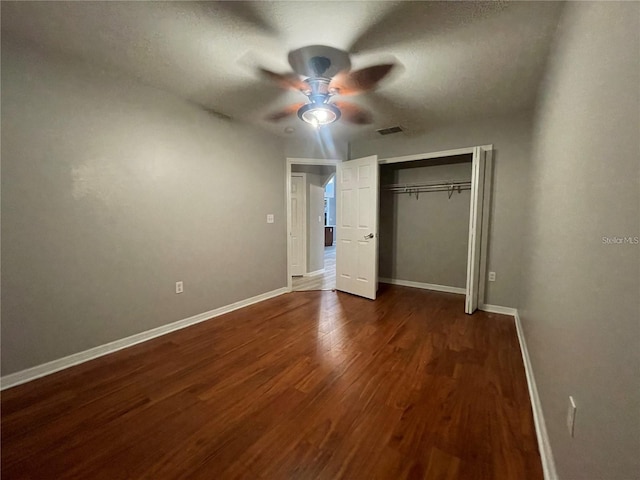 unfurnished bedroom with ceiling fan, a closet, and dark hardwood / wood-style floors