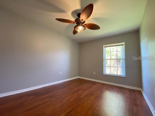 empty room with ceiling fan and dark wood-type flooring