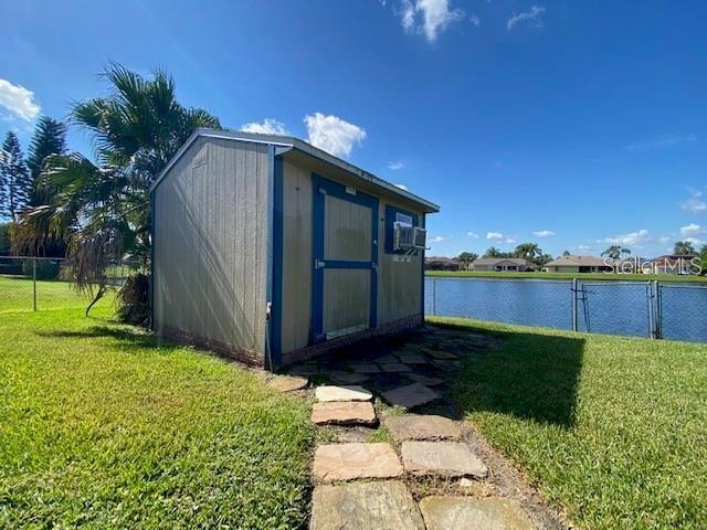 view of outdoor structure featuring a water view and a yard