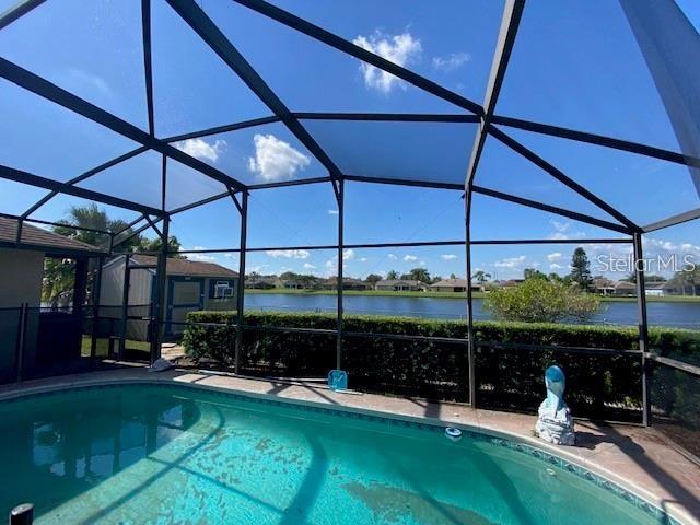 view of pool with a water view and a lanai