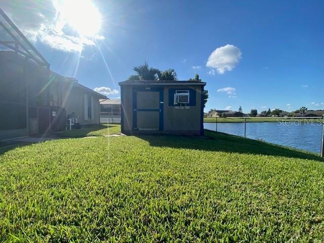 view of yard featuring a water view and a storage shed