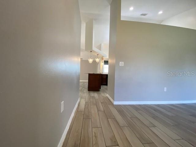 hall featuring a notable chandelier and light wood-type flooring