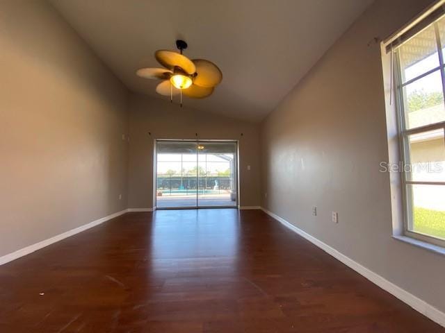 spare room with ceiling fan, lofted ceiling, and dark wood-type flooring