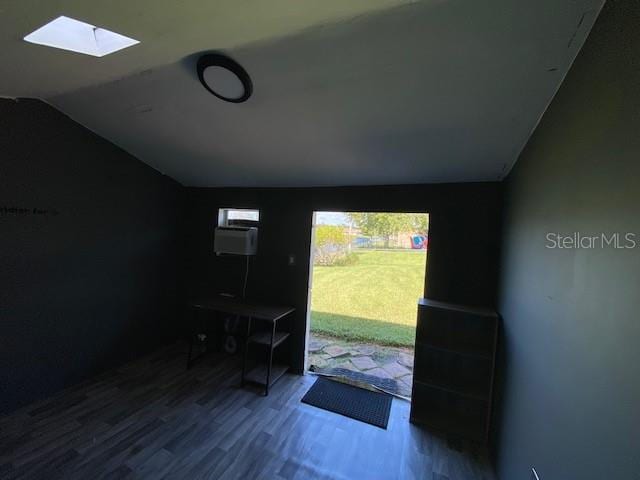 doorway featuring vaulted ceiling with skylight and hardwood / wood-style floors