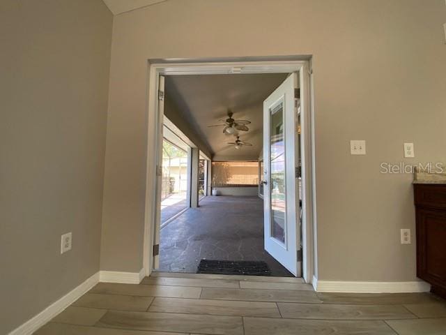 hallway with light hardwood / wood-style floors and lofted ceiling