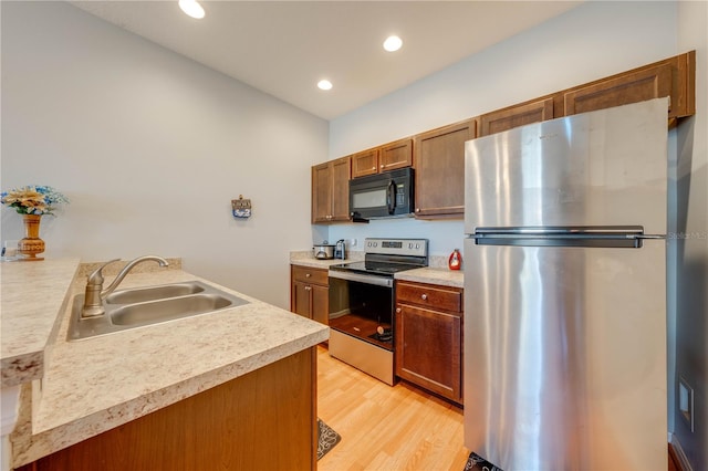 kitchen with sink, light hardwood / wood-style floors, and appliances with stainless steel finishes