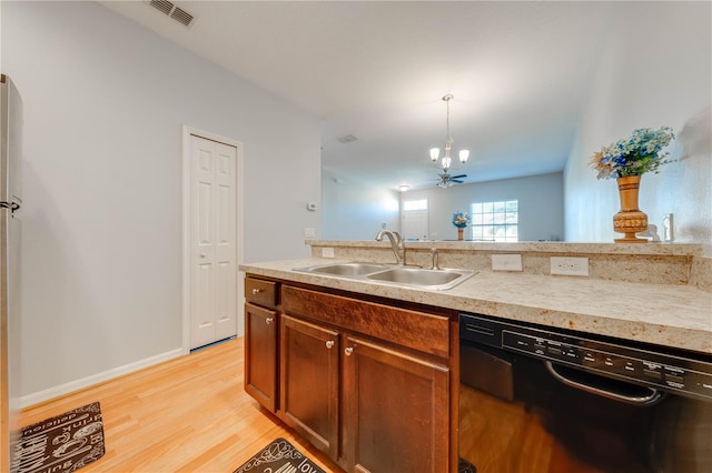 kitchen featuring pendant lighting, dishwasher, ceiling fan with notable chandelier, sink, and light hardwood / wood-style flooring