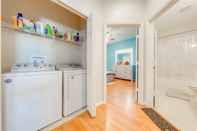 laundry area featuring ceiling fan, washing machine and dryer, and wood-type flooring